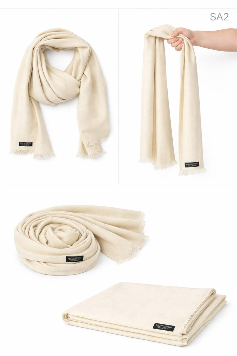 Four views of an Ivory Cream SA Series mixed cashmere scarf, including draped, held, rolled, and folded styles with a black artisan label.